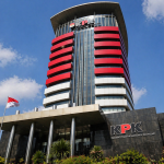 Gedung Komisi Pemberantasan Korupsi (KPK) dengan bendera Indonesia, simbol upaya pencegahan korupsi dalam partai politik melalui transparansi, pembatasan masa jabatan ketua umum, dan sistem kaderisasi yang lebih baik.