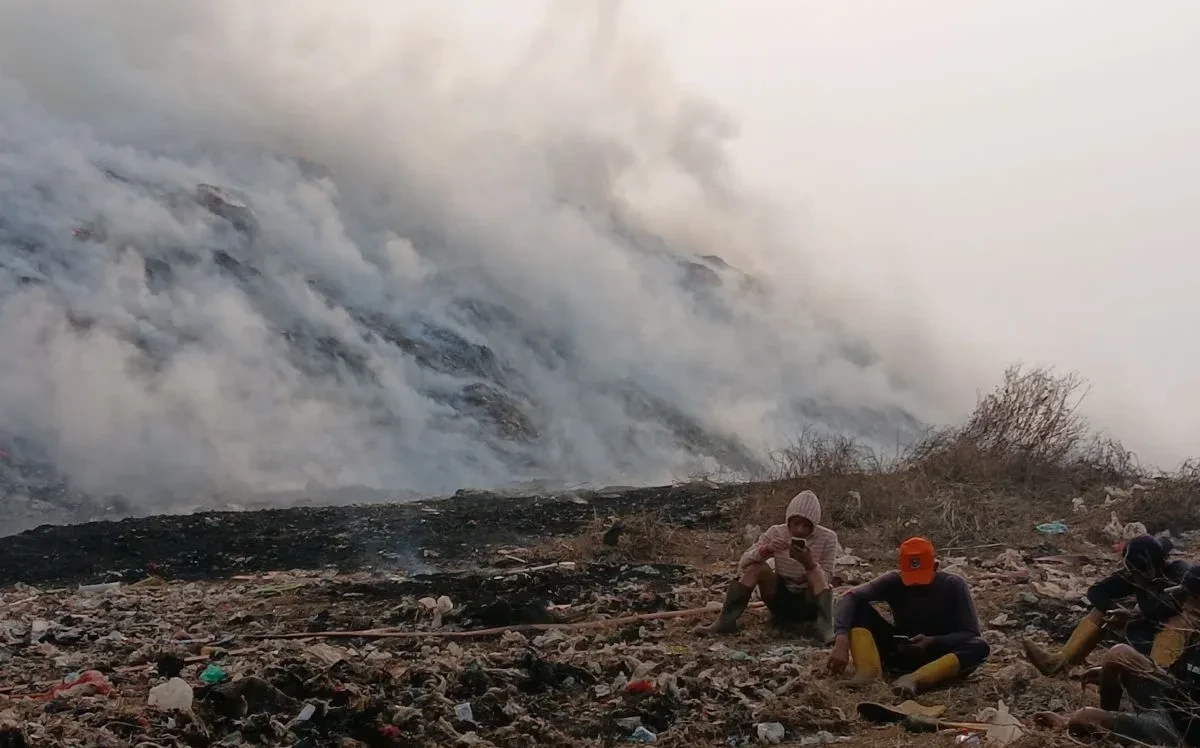 Petugas menangani kebakaran TPA Jatiwaringin Tangerang dengan latar kepulan asap tebal di Tempat Pembuangan Akhir (TPA) Jatiwaringin, Kecamatan Mauk, Kabupaten Tangerang.
